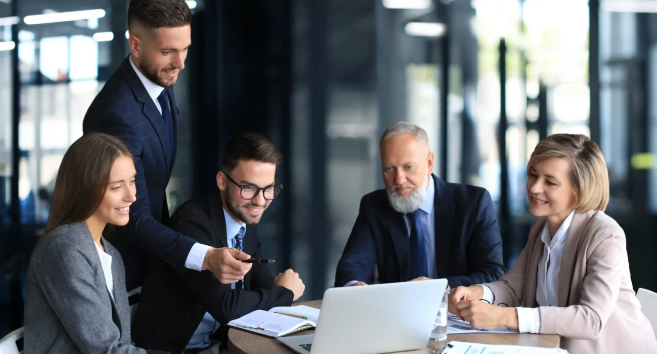 office workers collaborating with someone on a laptop screen