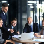 office workers collaborating with someone on a laptop screen