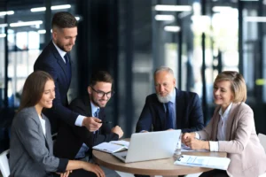 office workers collaborating with someone on a laptop screen
