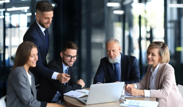 office workers collaborating with someone on a laptop screen
