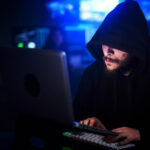 hooded man sneaking into outdated applications in shop floor