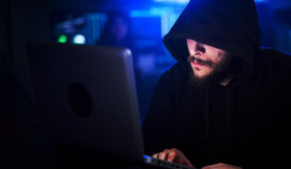 hooded man sneaking into outdated applications in shop floor